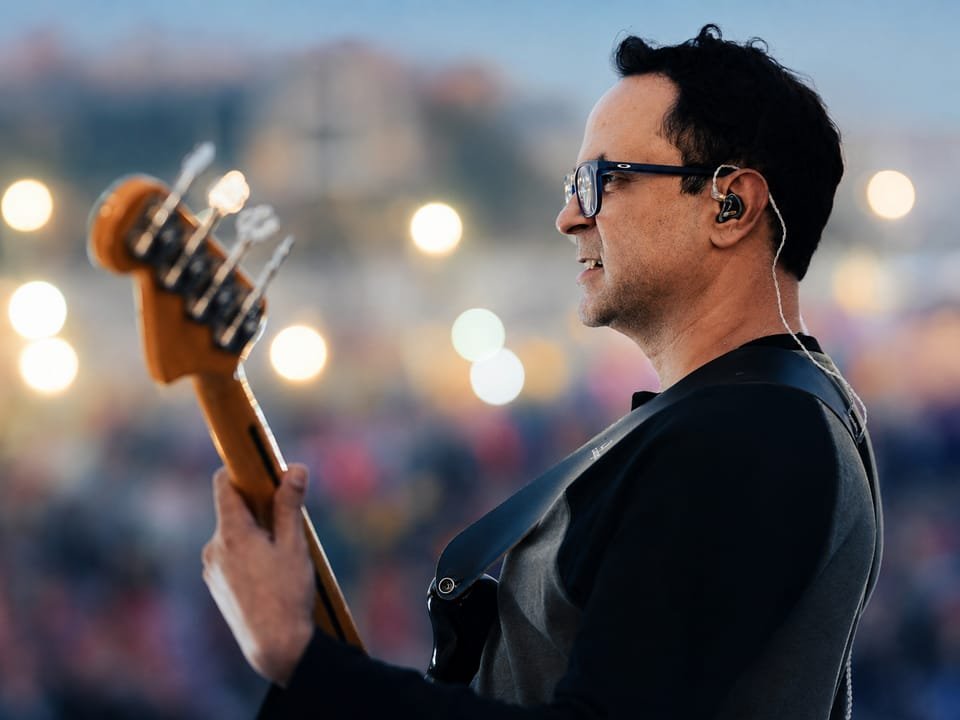 YAM musician performing with a bass guitar on stage